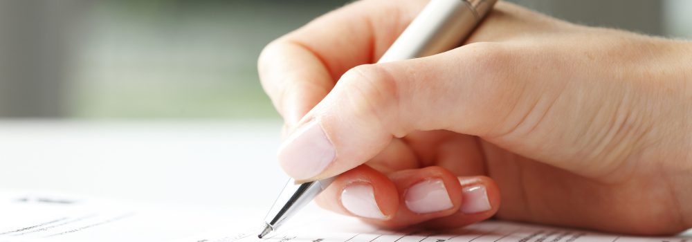 Businesswoman writing on a form